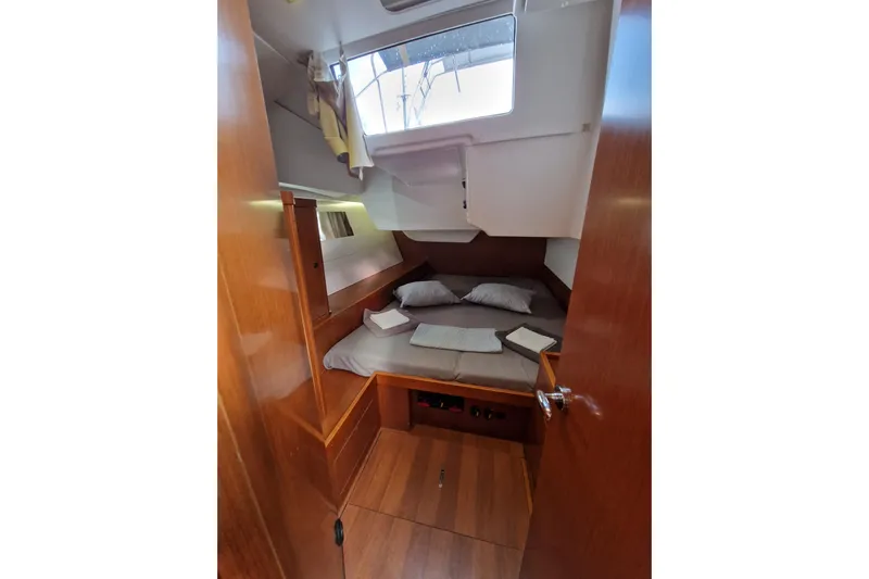  Yacht Photos Pics 2014 Beneteau Oceanis 48 cabin interior with cozy bed and wooden finish.