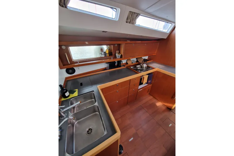  Yacht Photos Pics 2014 Beneteau Oceanis 48 yacht kitchen with modern wood cabinetry and stainless steel sink.