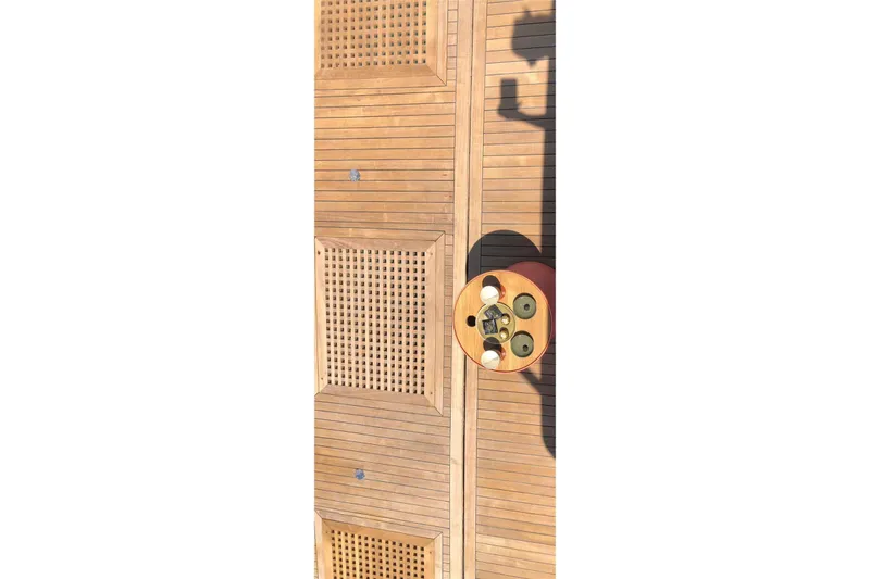 Axella Yacht Photos Pics Wooden deck of 1991 Crestitalia 33m yacht with circular table and shadows.