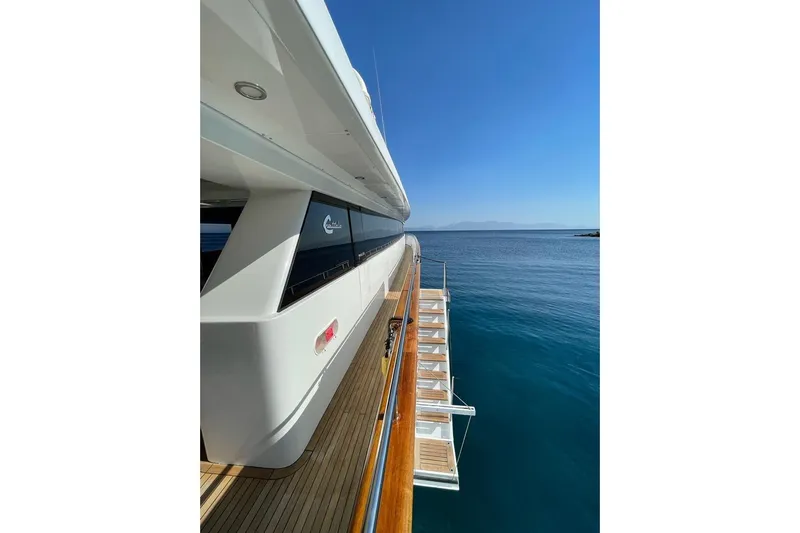 Axella Yacht Photos Pics Luxurious 1991 Crestitalia 33m yacht with sleek design, docked by serene blue waters.