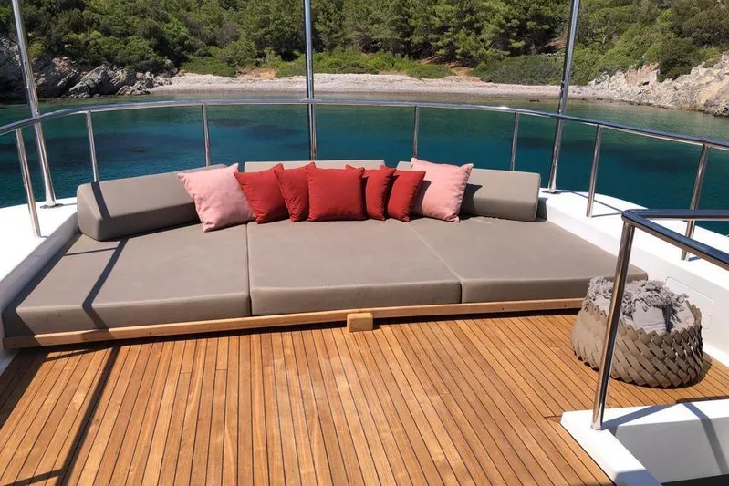 Axella Yacht Photos Pics Luxurious Crestitalia 33m yacht deck with cushions, overlooking serene turquoise waters, 1991 model.