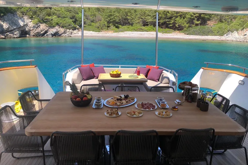 Axella Yacht Photos Pics Luxurious dining setup on a 1991 Crestitalia 33m yacht with scenic ocean view.