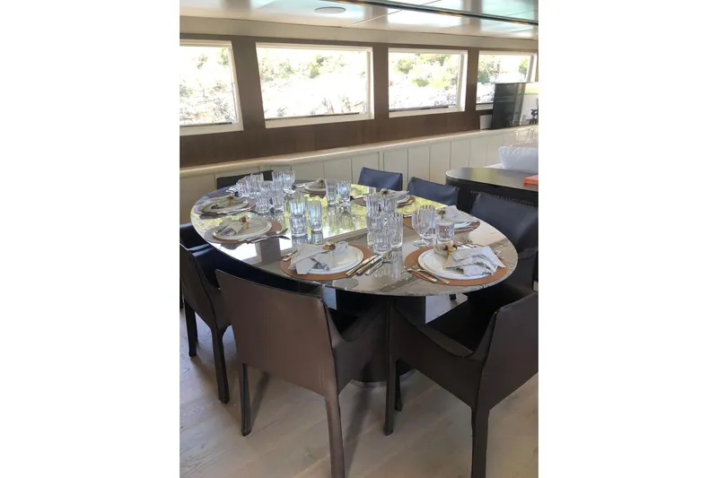 Axella Yacht Photos Pics Luxurious dining area on 1991 Crestitalia 33m yacht, elegantly set table with glassware.