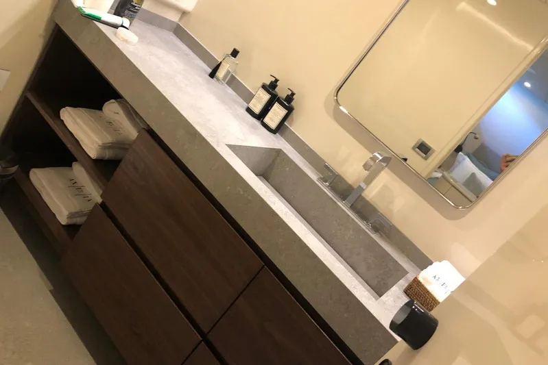 Axella Yacht Photos Pics Modern bathroom vanity with sleek sink, mirror, and toiletries on a Crestitalia 33m yacht, 1991.