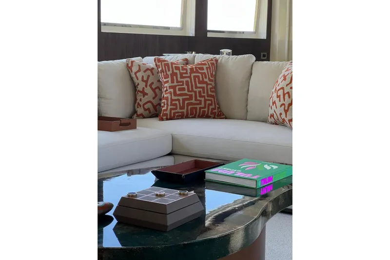 Axella Yacht Photos Pics Luxurious yacht interior with patterned cushions, modern decor, and a glossy coffee table. Crestitalia 33m, 1991.