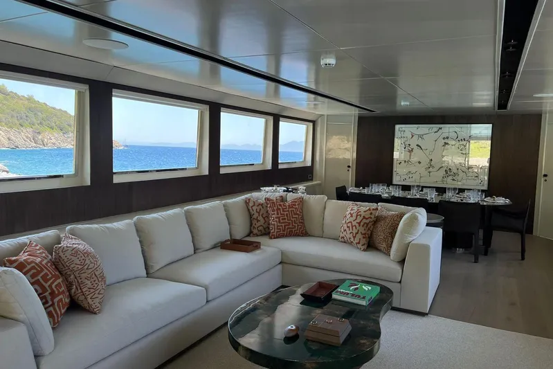 Axella Yacht Photos Pics Luxurious yacht interior with elegant seating, dining area, and ocean view through large windows. Crestitalia 33m, 1991.