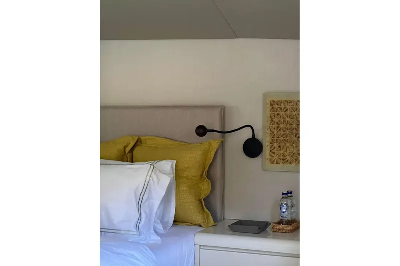 Axella Yacht Photos Pics Bedroom interior with yellow pillows, wall lamp, and decorative panel in a 1991 Crestitalia 33m.