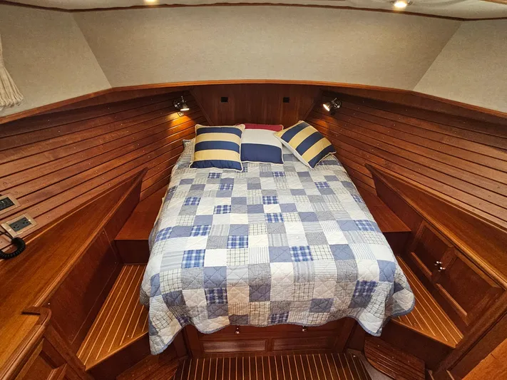 Journey Yacht Photos Pics Cozy cabin interior of 2007 Grand Banks 39 Eastbay SX with quilted bed and wooden paneling.