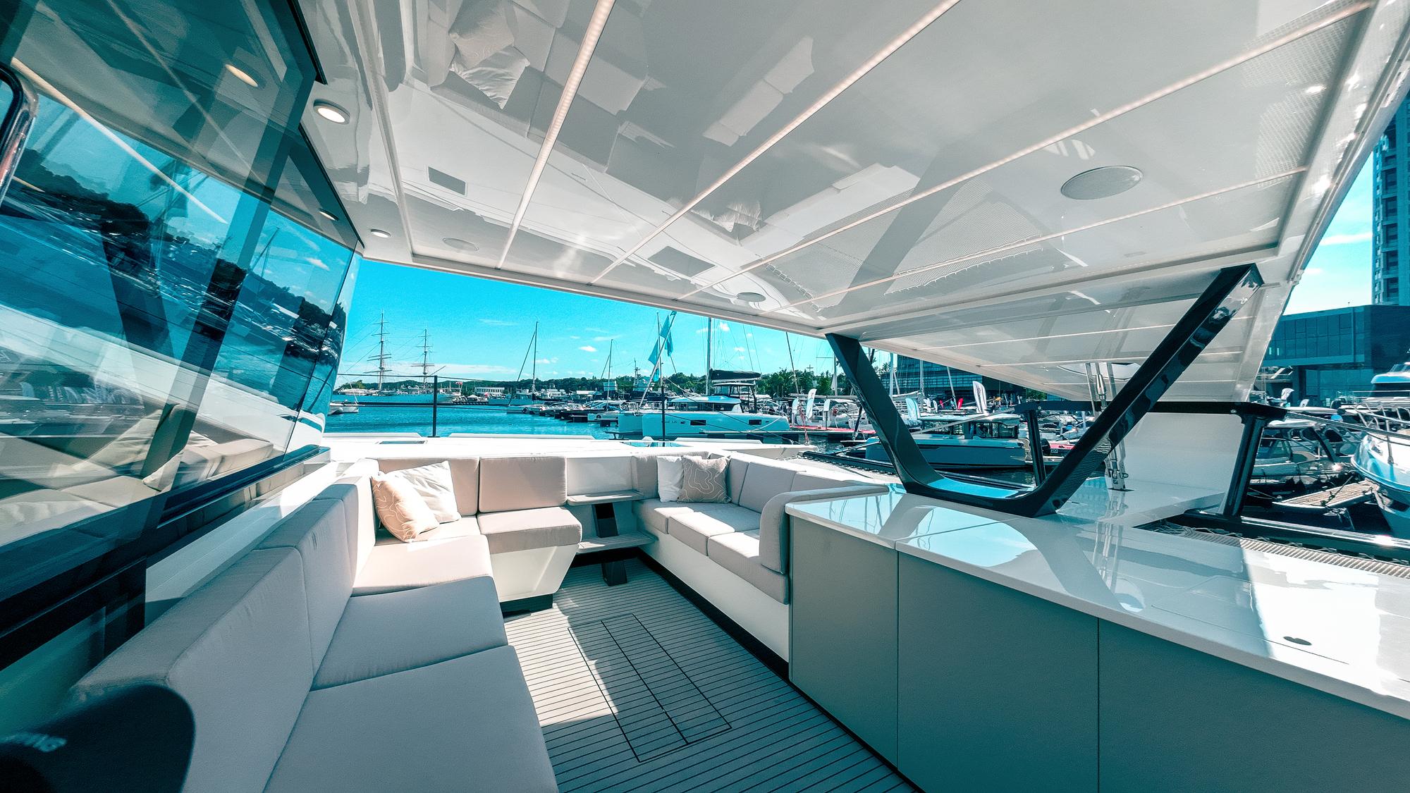 Luxurious 2024 Wave 60 yacht interior with spacious seating and marina view.