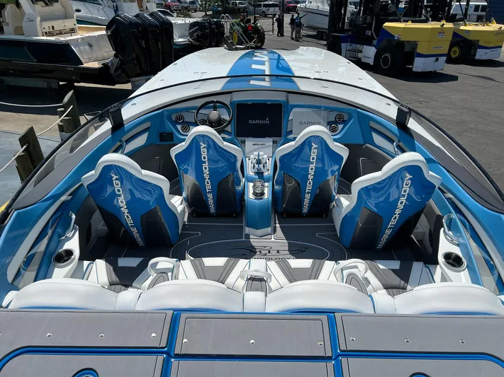 El Gato Yacht Photos Pics 2022 MTI 390X boat interior with blue and white seats, advanced dashboard technology.