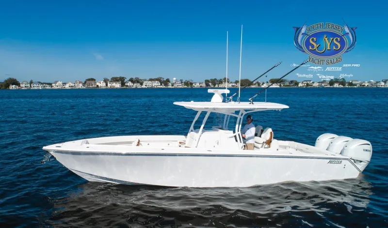  Yacht Photos Pics 2024 Jupiter 34 boat cruising on a calm lake near a residential area.