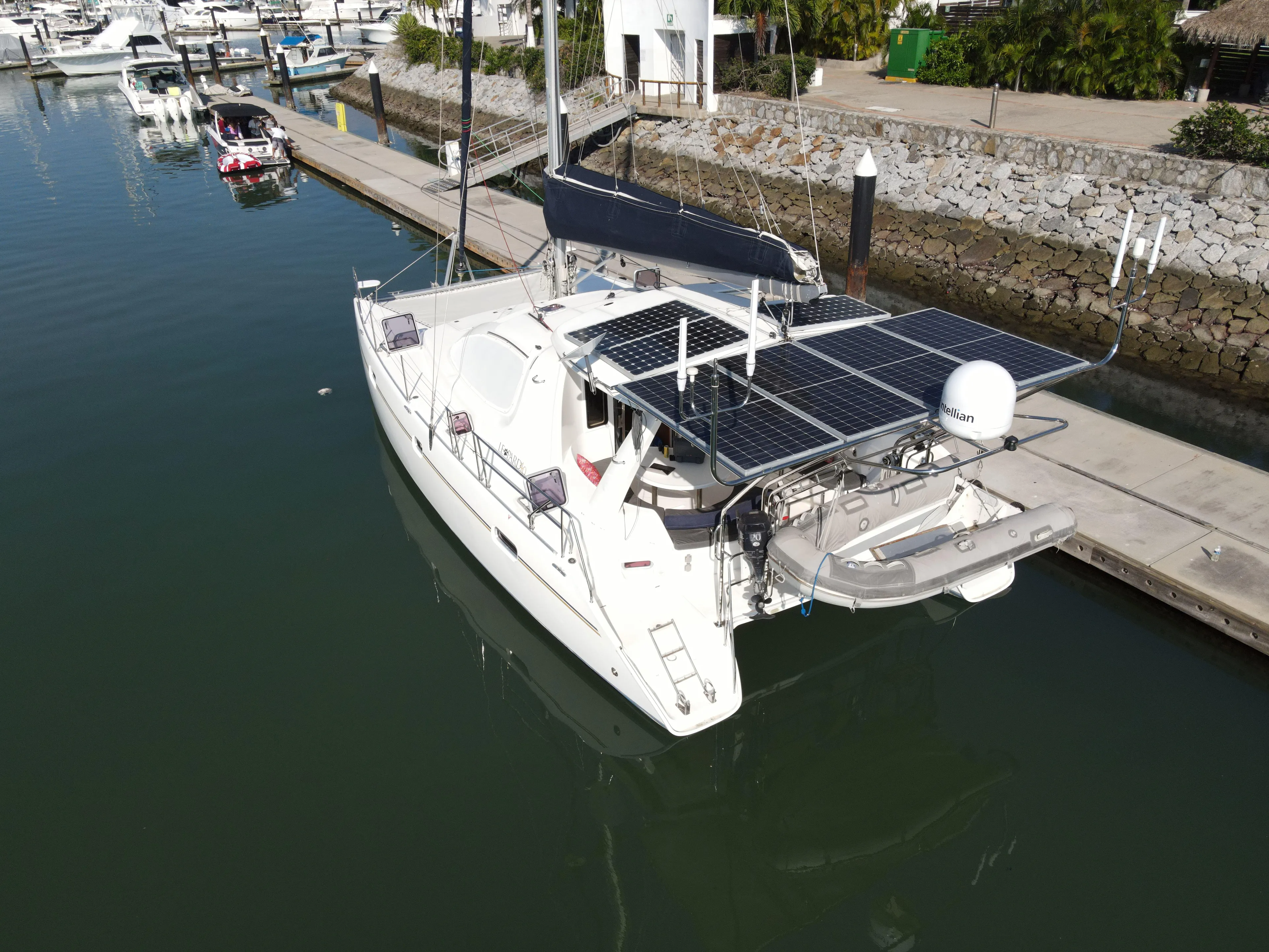  Yacht Photos Pics 2010 Leopard 40 catamaran docked, featuring solar panels and a dinghy.