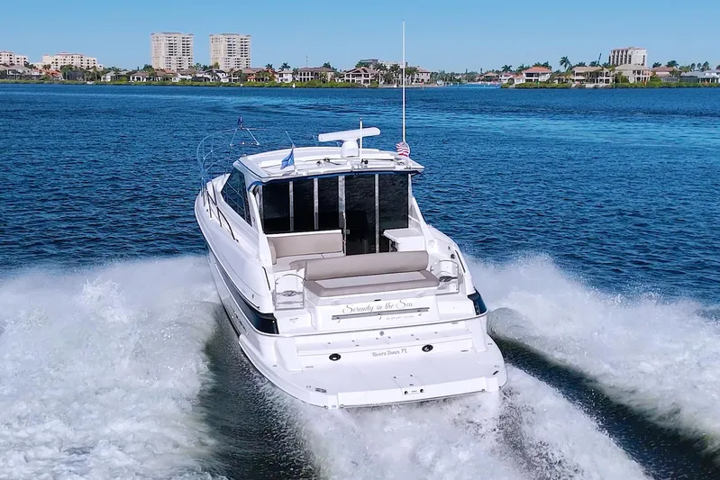 Serenity In The Sea Yacht Photos Pics 2014 Regal 46 Sport Coupe cruising on a scenic waterway with city skyline backdrop.