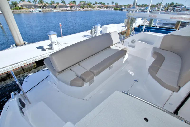 Serenity In The Sea Yacht Photos Pics 2014 Regal 46 Sport Coupe yacht with spacious seating, docked by a serene waterfront.