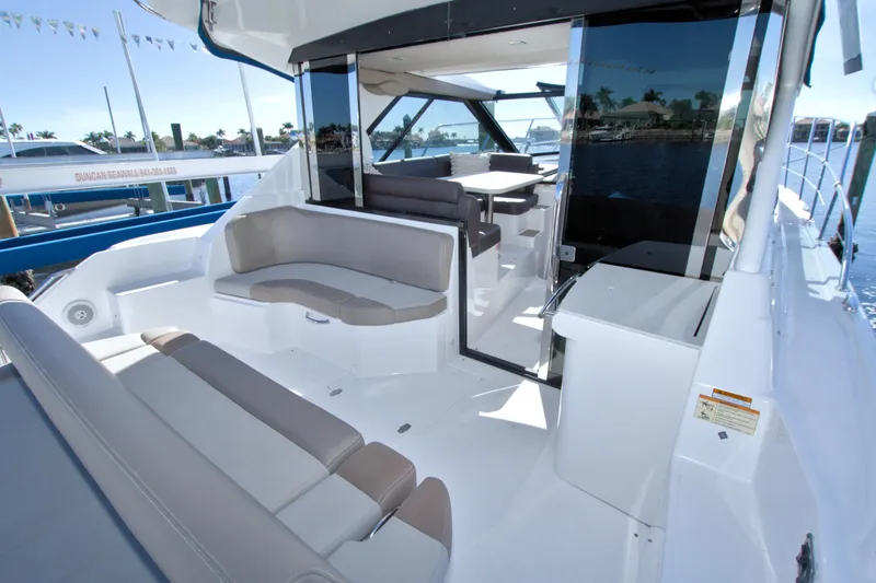 Serenity In The Sea Yacht Photos Pics 2014 Regal 46 Sport Coupe yacht interior with seating and table, docked by the water.