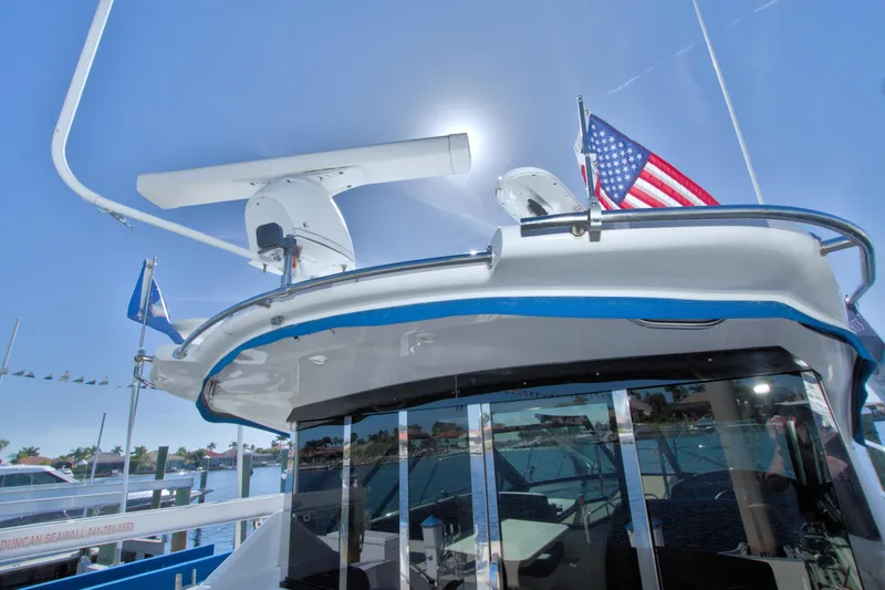 Serenity In The Sea Yacht Photos Pics 2014 Regal 46 Sport Coupe yacht with flags, docked under clear blue sky.