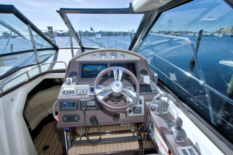 Serenity In The Sea Yacht Photos Pics Cockpit view of 2014 Regal 46 Sport Coupe yacht with steering wheel and navigation controls.