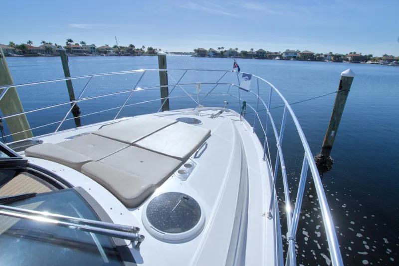 Serenity In The Sea Yacht Photos Pics 2014 Regal 46 Sport Coupe yacht docked, featuring spacious sunbathing area and scenic waterfront view.