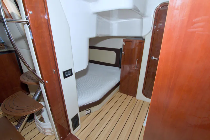 Serenity In The Sea Yacht Photos Pics 2014 Regal 46 Sport Coupe cabin interior with wooden finishes and compact bed.