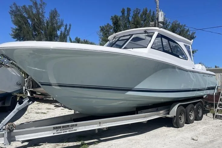  Yacht Photos Pics 2026 Southport 33 DC boat on trailer, parked outdoors under clear blue sky.