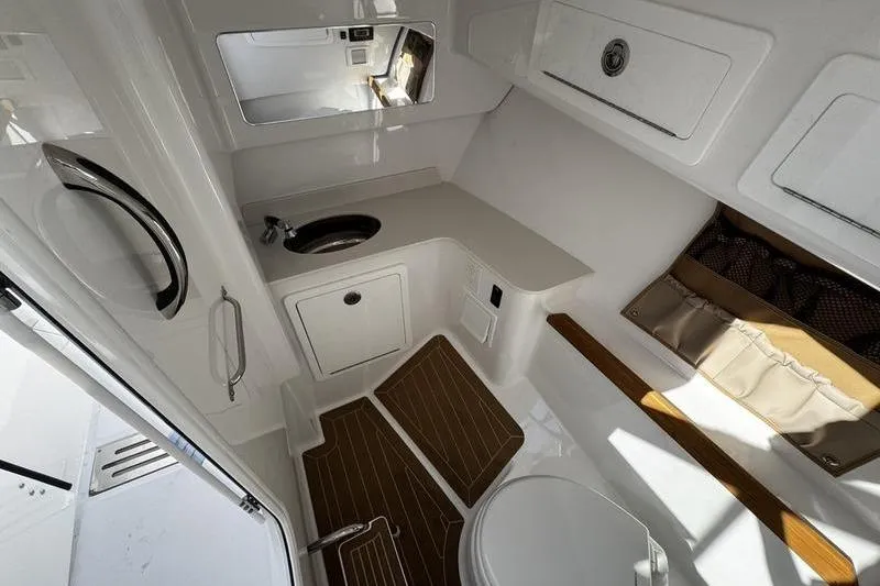  Yacht Photos Pics 2026 Southport 33 DC boat interior with modern bathroom, featuring sink, toilet, and storage.