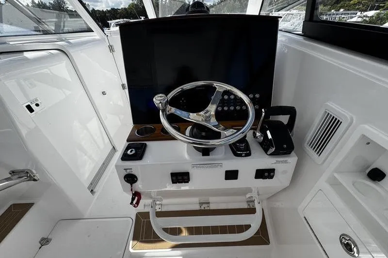  Yacht Photos Pics 2026 Southport 33 DC boat helm with steering wheel and control panel.