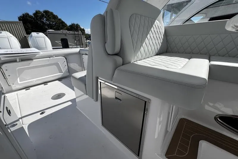  Yacht Photos Pics 2026 Southport 33 DC boat interior with white seating and storage compartment.