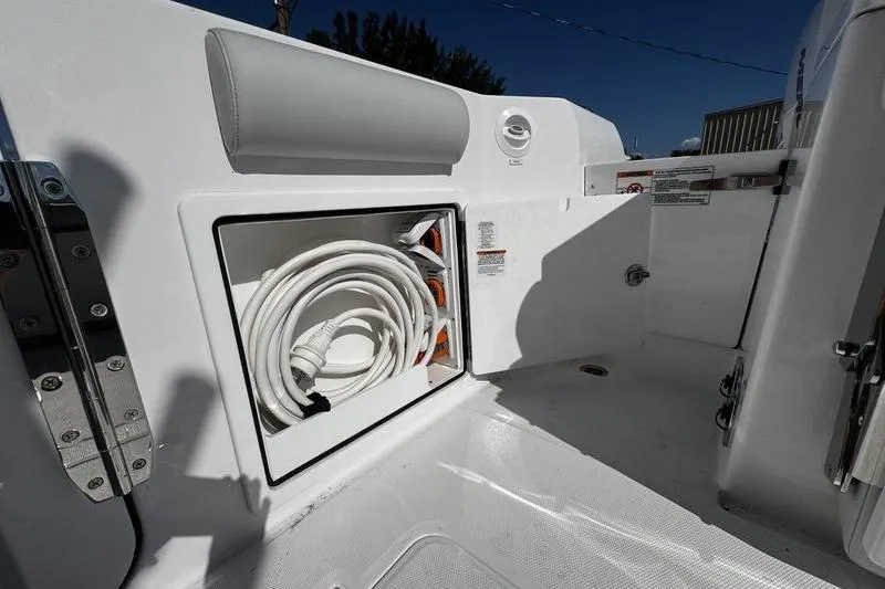  Yacht Photos Pics 2026 Southport 33 DC boat storage compartment with coiled hose and sleek design.