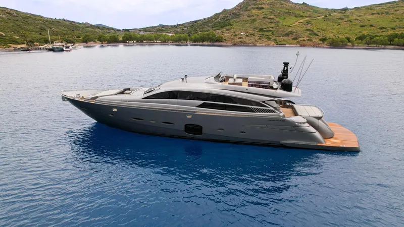  Yacht Photos Pics Luxury 2012 Pershing 92 yacht anchored in serene blue waters, surrounded by lush green hills.