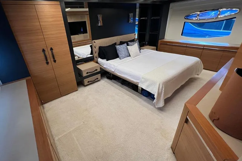  Yacht Photos Pics Luxurious bedroom interior of a 2012 Pershing 92 yacht with modern furnishings and large window.