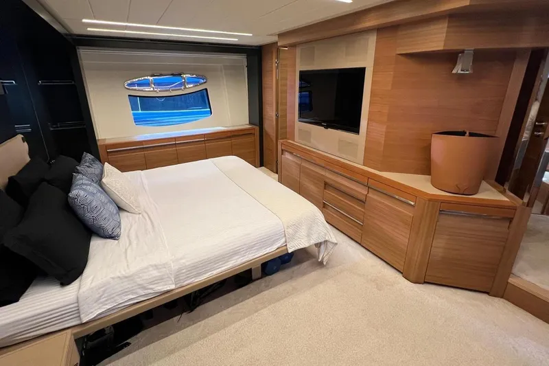  Yacht Photos Pics Luxurious bedroom interior of 2012 Pershing 92 yacht with modern wood finishes and large window.