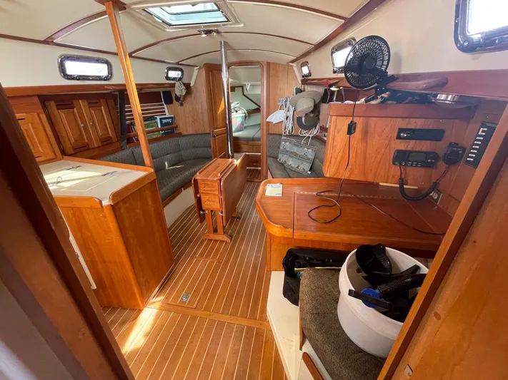 Bell Canto Yacht Photos Pics Interior of 2006 Tartan 3400 sailboat with wooden furnishings and seating area.