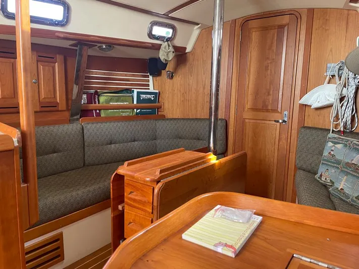 Bell Canto Yacht Photos Pics Cozy interior of 2006 Tartan 3400 sailboat with wooden furnishings and seating area.