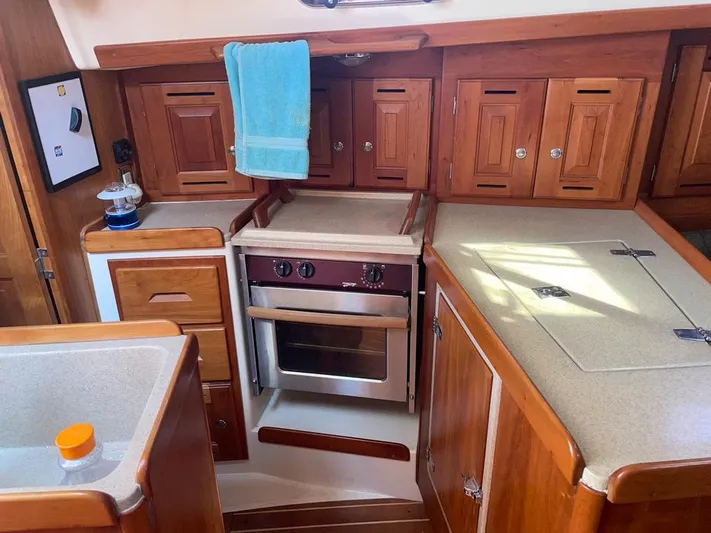 Bell Canto Yacht Photos Pics Tartan 3400 2006 yacht kitchen with wooden cabinets and modern appliances.