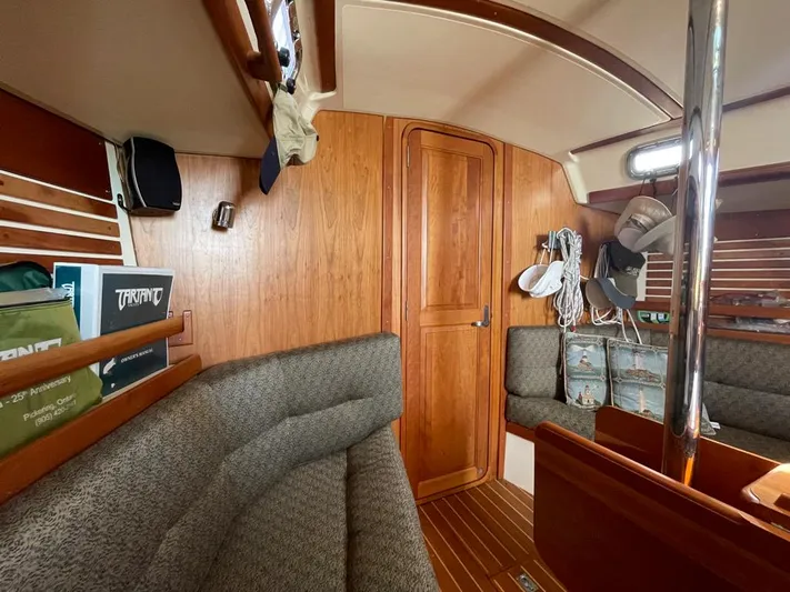 Bell Canto Yacht Photos Pics Interior of a 2006 Tartan 3400 sailboat with wood paneling and seating area.