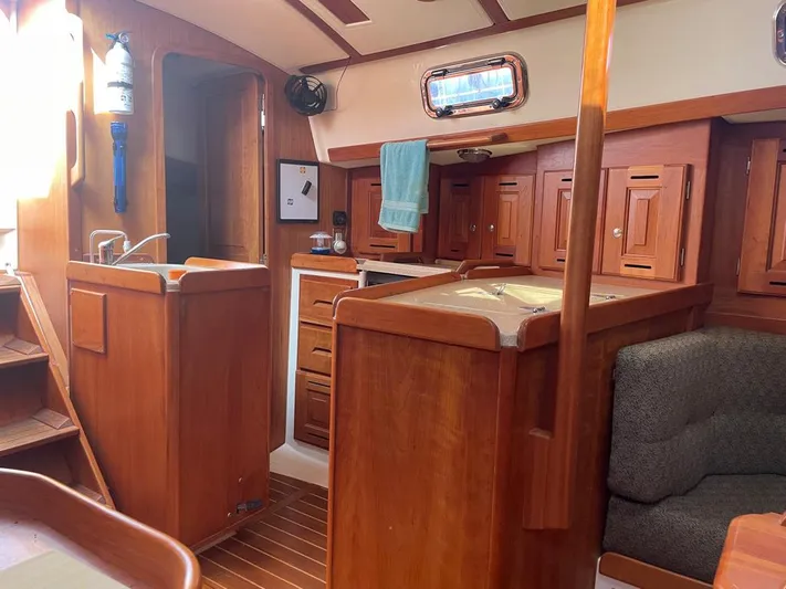 Bell Canto Yacht Photos Pics Interior of 2006 Tartan 3400 sailboat with wooden cabinetry and cozy seating area.