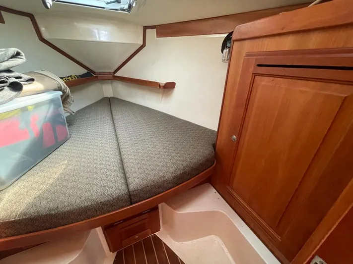 Bell Canto Yacht Photos Pics Cozy cabin interior of 2006 Tartan 3400 sailboat with wooden cabinetry and cushioned berth.