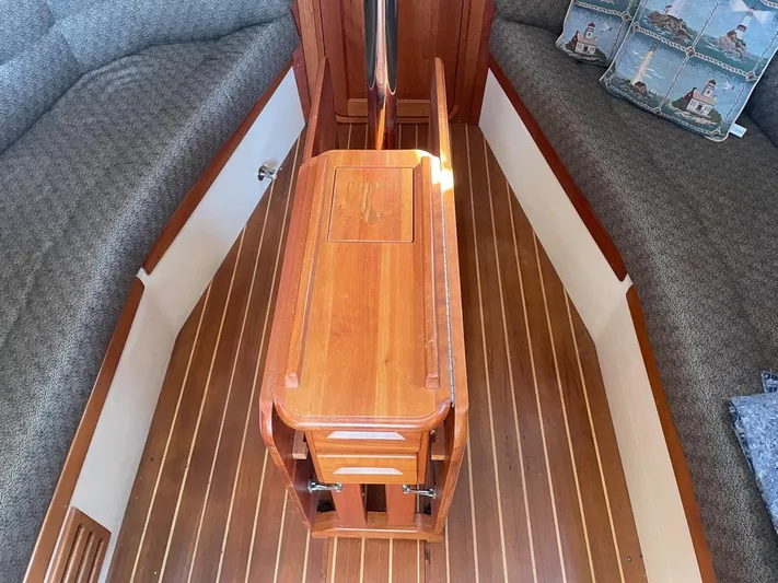 Bell Canto Yacht Photos Pics Interior of 2006 Tartan 3400 sailboat with wooden table and cushioned seating.