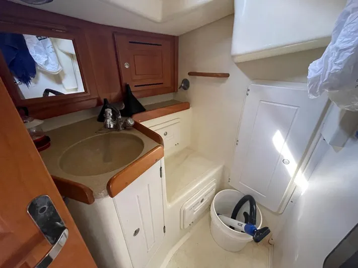Bell Canto Yacht Photos Pics 2006 Tartan 3400 yacht bathroom with sink, mirror, and storage cabinets.