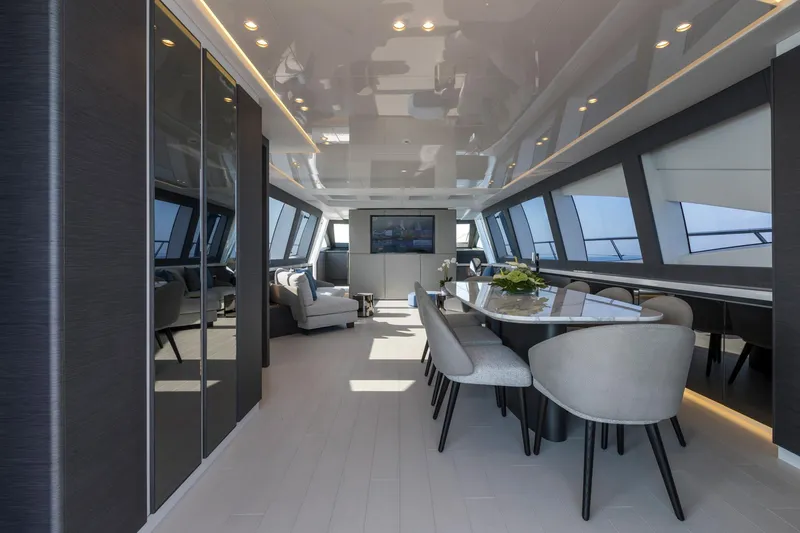 Nana I Yacht Photos Pics Luxurious interior of 2020 Mangusta 110 Open yacht with modern dining area and panoramic windows.