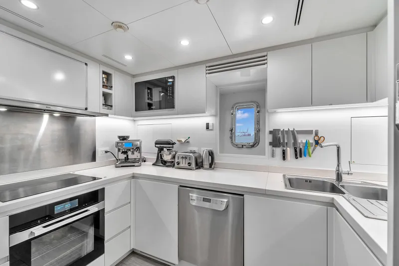 Nana I Yacht Photos Pics Modern kitchen interior on 2020 Mangusta 110 Open yacht, featuring sleek appliances and ocean view.