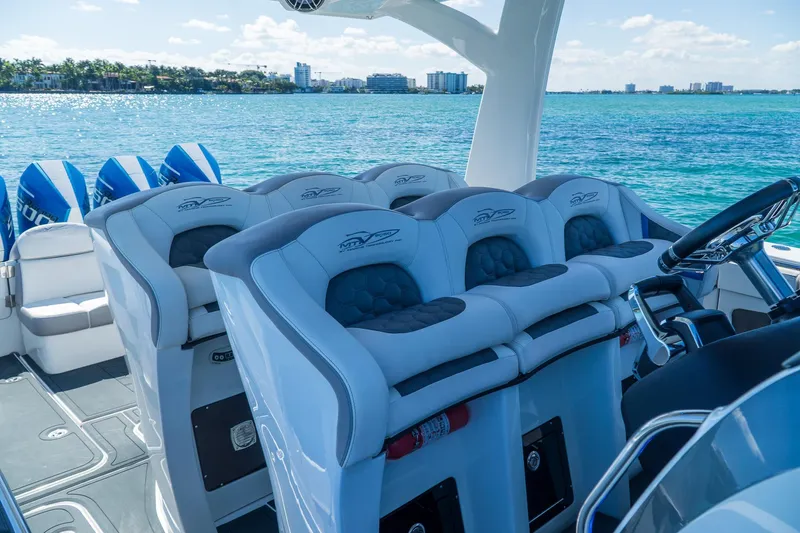  Yacht Photos Pics Luxury MTI 50v boat interior with plush seating, overlooking serene blue waters, 2023 model.