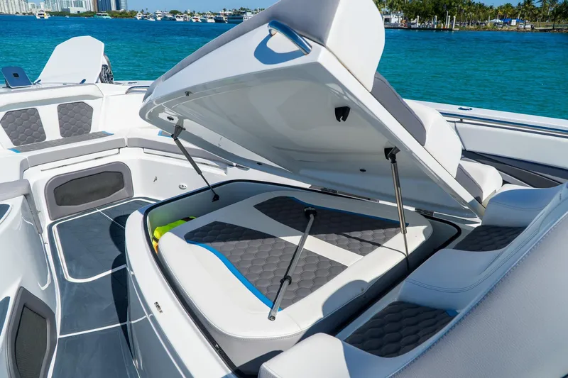  Yacht Photos Pics 2023 MTI 50v boat interior with open storage compartment, featuring sleek seating and ocean backdrop.