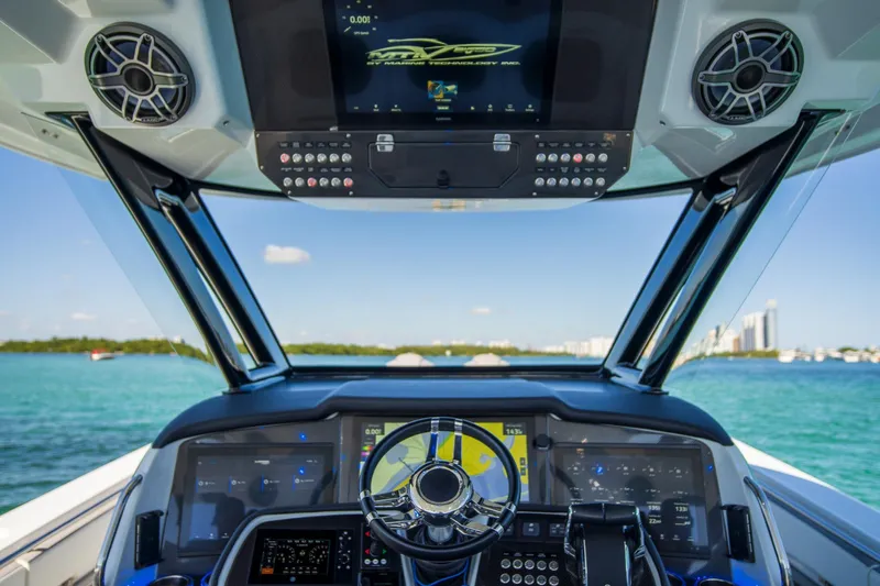  Yacht Photos Pics Cockpit view of 2023 MTI 50v boat with advanced navigation system and ocean backdrop.