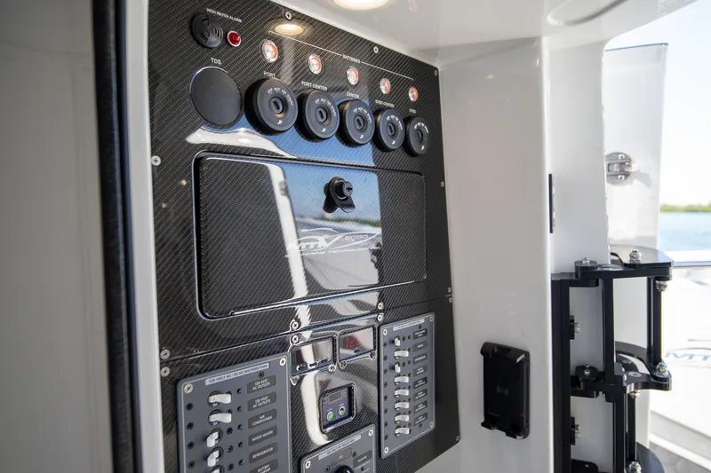  Yacht Photos Pics Control panel of 2023 MTI 50v boat with carbon fiber finish and switches.