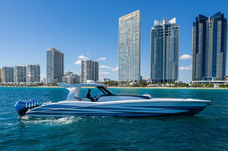  Yacht Photos Pics 2023 MTI 50v boat cruising near modern city skyline on a sunny day.