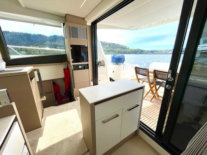 M.y. Blu Dayz Yacht Photos Pics Modern interior of 2023 Prestige 520 yacht with outdoor seating and scenic water view.