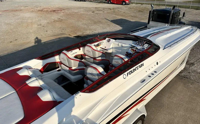  Yacht Photos Pics 2007 Fountain 47 Lightning speedboat with red and white interior, parked on concrete.