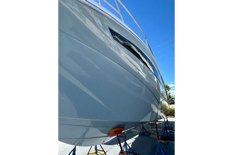  Yacht Photos Pics 2024 NX 360 Sport Coupe yacht on stands, viewed from below against a clear blue sky.