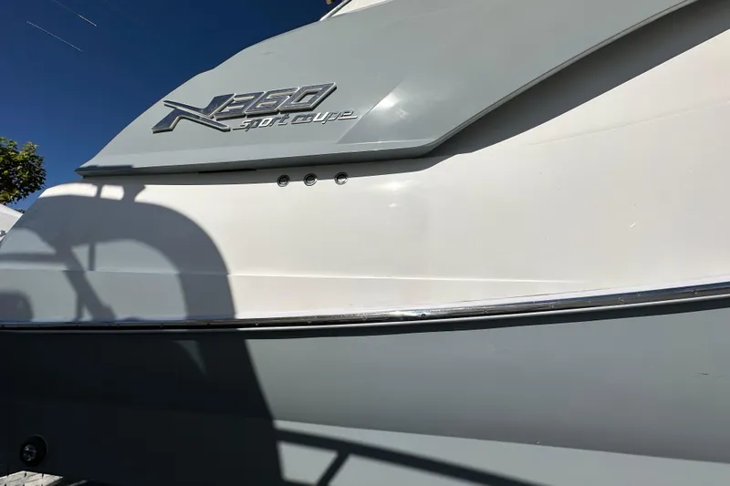  Yacht Photos Pics 2024 NX 360 Sport Coupe boat exterior with sleek design and logo detail.